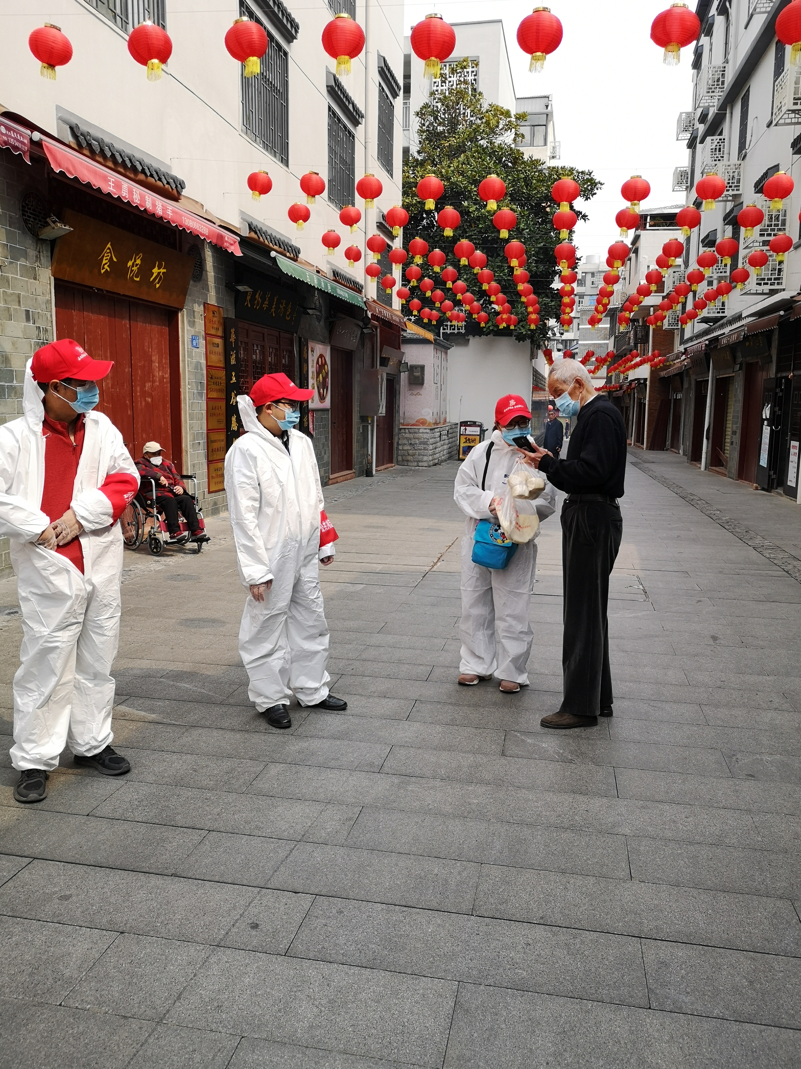 社區(qū)居民在展示他給組員拍下的工作照.jpg 社區(qū)居民在展示他給組員拍下的工作照.jpg